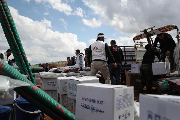敘利亚西北部一个境内流离失所者营地，卡车载满毯子和卫生包等必需品。