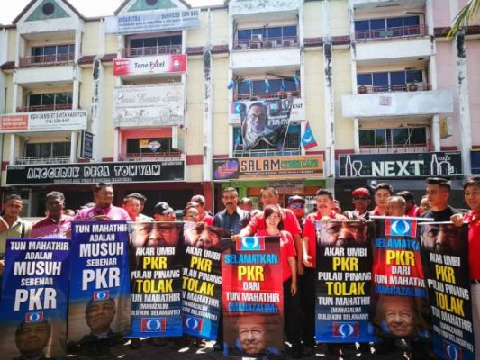 近50人聚集在公正党槟州总部前，抗议马哈迪使用蓝眼标志上阵大选。
