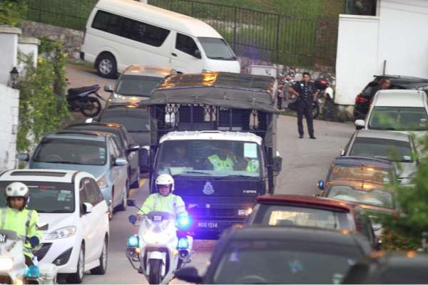 警用大卡车在交警护送下离开纳吉家。