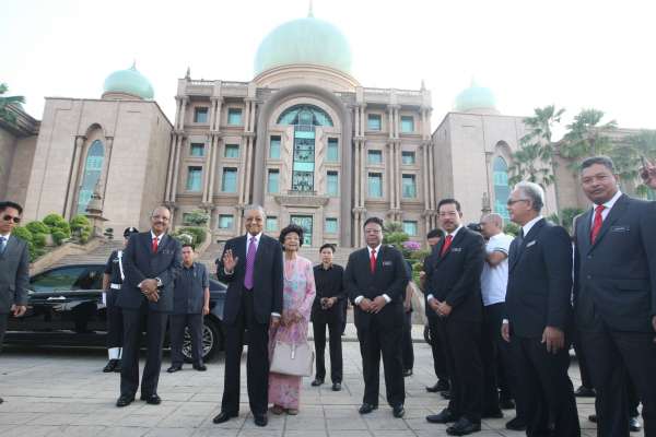 首相马哈迪（中）与夫人敦西蒂哈丝玛医生在阿里韩沙（右）的迎接下，步入首相署广场出席常月集会。 