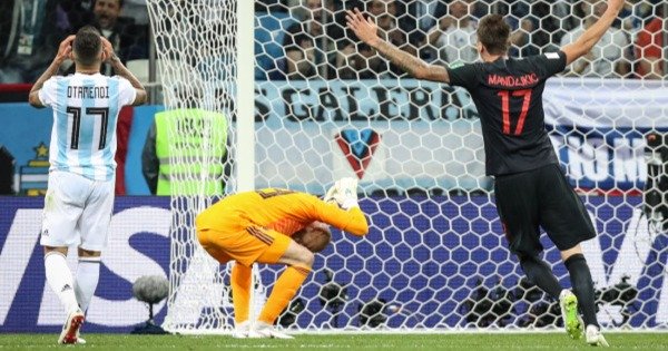 阿根廷队门将卡巴列罗（中）在克罗地亚队球员雷比奇进球后懊恼不已。 