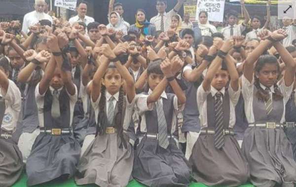 一批学童高举绑上黑带的双手抗议。