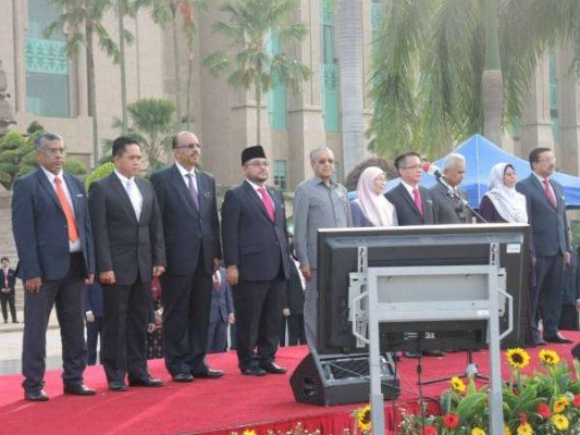 首相马哈迪演讲时，哈尼巴（左一）在旁聆听。