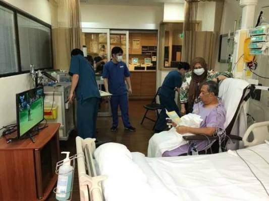 在病房内的慕尤丁戴着呼吸器，正在阅读文件。