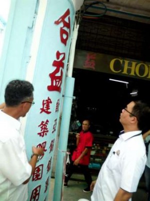 慕斯达法（左）与陈泓宾巡访麻坡丝丝街商家，并对墙柱雕刻中文字体特色谈论一番。