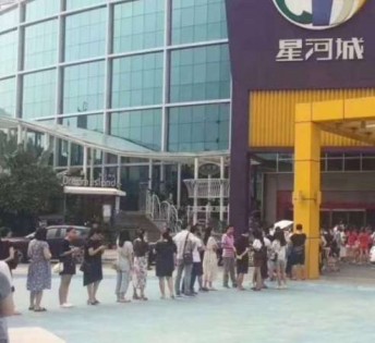 东莞大型购物中心“星河城”22日上午派发免费自助餐券，吸引大批民众排队领取。
