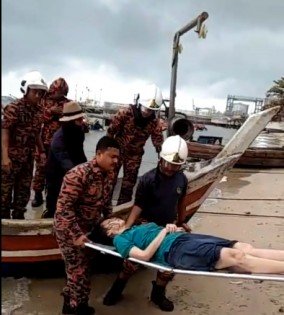 消拯员将被渔民救起的华妇送往医院。 