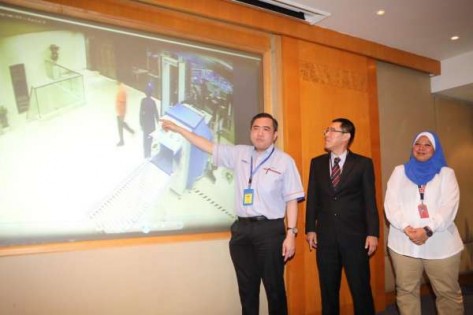 陆兆福(左)透过闭库电视录影证实维尼斯瓦兰(影片橙衣者)没有完成安检就擅闯机场贵宾室，右起为执勤员工诺费扎和拉惹阿兹米。