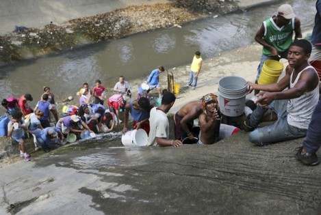 XFLL125-Main-2019-03-11T21-.jpg  委内瑞拉大停电星期一进入第5天，反对派国会已宣布全国进入警戒状态。图为加拉加斯市民被迫在污水道取水。