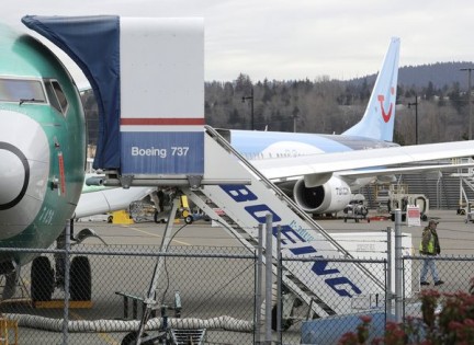 In this photo taken Monday, March 11, 2019, a Boeing 737 MAX 8 airplane being built for TUI Group sits parked in the background at right at Boeing Co.'s Renton Assembly Plant in Renton, Wash. Britain, France and Germany on Tuesday joined a rapidly growing number of countries grounding the new Boeing plane involved in the Ethiopian Airlines disaster or turning it back from their airspace, while investigators in Ethiopia looked for parallels with a similar crash just five months ago. (AP Photo/Ted S. Warren)