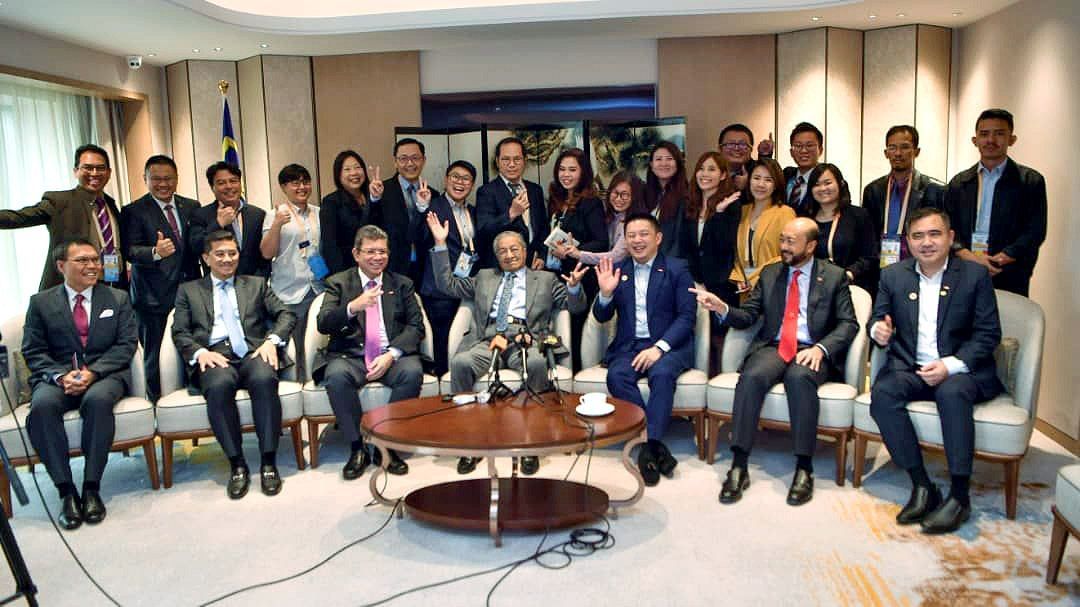 马哈迪（坐者中）与部长及新闻从业员在摄影师喊出“自由式”后，立即摆出逗趣的姿势。坐者左起慕哈莫末沙鲁、阿兹敏及赛夫丁；右起陆兆福、慕克力及雷京。 