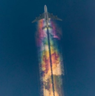 德国一名20岁摄影师在自家后院捕捉到一个奇景，飞机在天空画出一道“彩虹飞机云”。（网络图）