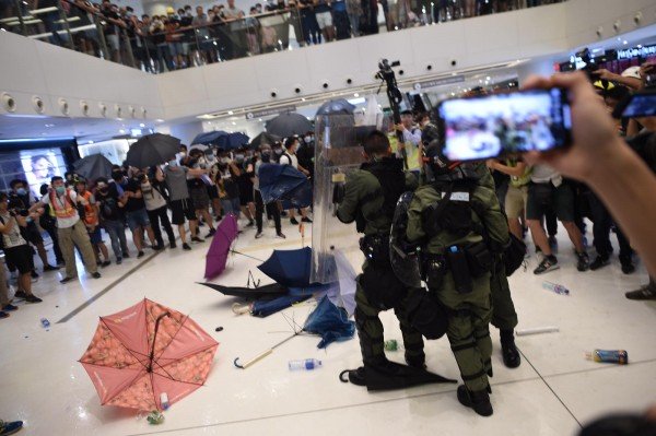 示威者向警方投掷雨伞、砖头、水瓶等杂物，警察则用盾牌阻挡，并以警棍尝试驱赶示威者。
