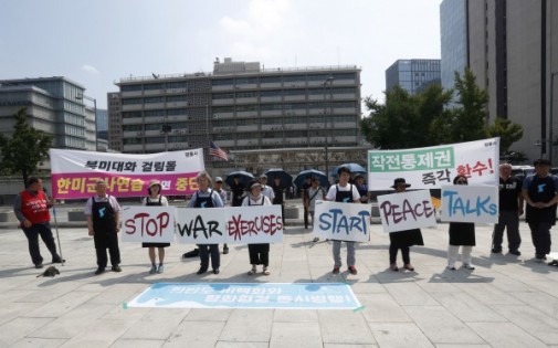 在美国驻首尔大使馆附近，抗议者星期一展示横幅和标语牌，反对韩国和美国举行军事演习。英文标语写着：“停止战争演习”和“开始和平谈判”。（美联社）