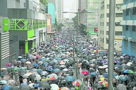 示威者撑伞冒雨参与“荃葵青”游行。（欧新社）