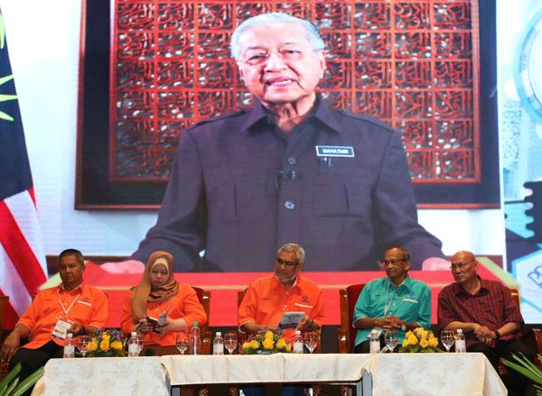 甘榜峇鲁地主在交流会上通过荧幕观看马哈迪演讲视频，右三起为卡立沙末与丽娜。