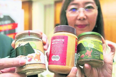 郭素沁展示三款不含棕油的花生酱，并质问为何要标签“不含棕油”。