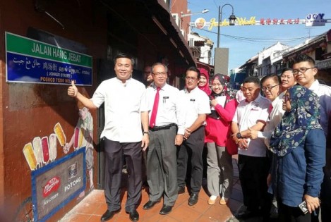 马六甲州行政议员拿督郑国球（左起）、市长拿督曼苏及市政局秘书阿斯哈为贴在鸡场街的5语路牌揭幕。