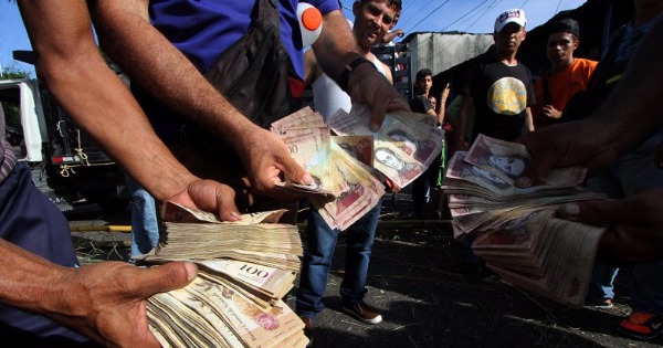 示威民众展示停用的100玻利瓦尔钞票。