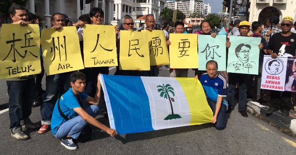 有一群支持者展示以中文书写的“槟州人民需要你，安华”大字报。