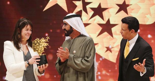 麦克唐奈（左）由阿联酋副总统兼总理马克图姆（中）手中接过奖项。（法新社图片）