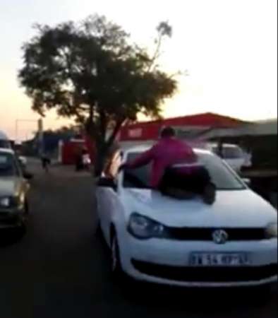 愤怒难当的妇人跳上其夫的汽车车头上。（互联网图片）