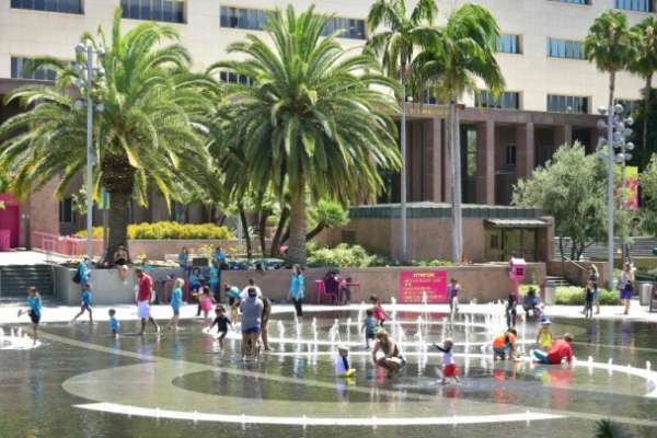 在洛杉矶，大批市民在一个商场外的喷水池嬉水消暑。（美联社图片）