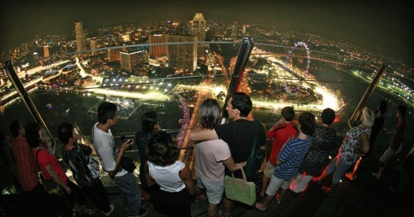 新加坡透过举办F1车赛，为该国每年平均带来1.5亿美元的观光财。图为观众观赏晚间F1赛车。（联合早报档案照）