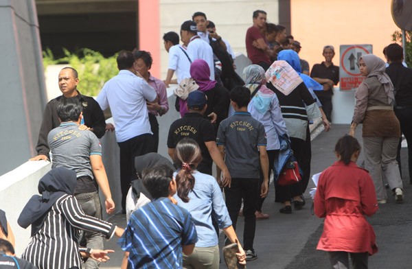 epa06466702 Employees walk outside a building after an earthquake caused office workers to flee swaying buildings, in Jakarta, Indonesia, 23 January 2018. Shakes were felt in Jakarta after a 6.0 magnitude earthquake hit 40 km south of Binuangeun, Indonesia, according to the United States Geological Survey (USGS). EPA-EFE/ADI WEDA