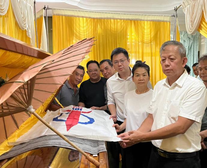 邹宇晖(左四起)、梁美明与胡智云为已故梁成祖棺木覆盖行动党党旗。