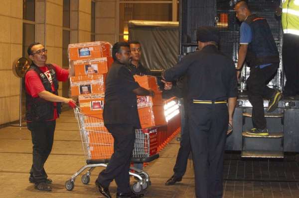 来自武吉阿曼商业罪案调查队的人员，在武吉免登一座高级公寓将多个装着名牌包包的箱子，运上大卡车。