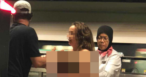 地铁站员工（右）拿了一条披肩给洋女围住她的身体。