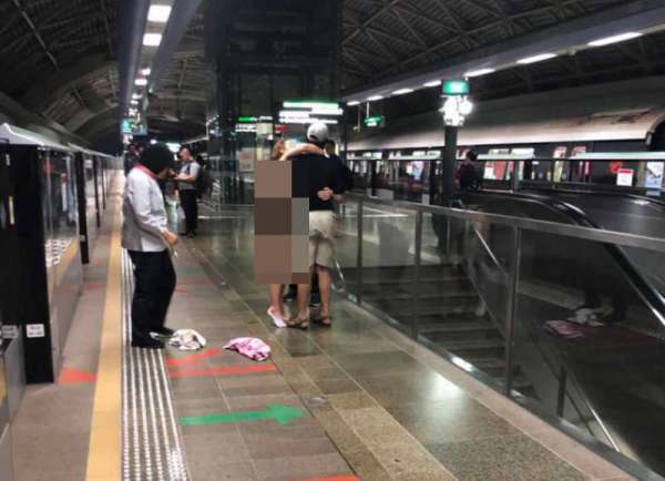 洋女将衣服脱光，地铁站月台周围可见她散落的衣物。 