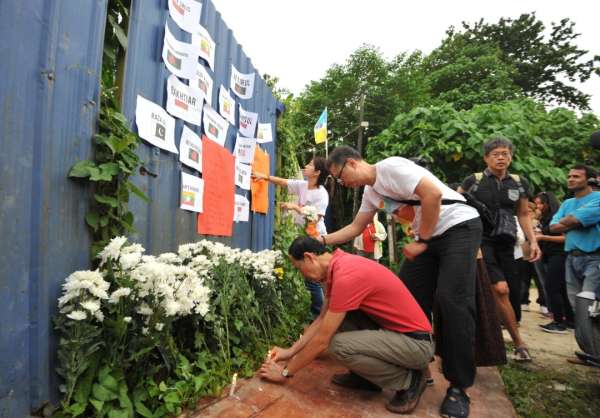 “槟城论坛“”成员把两宗土崩案死者名字贴在铁墙上，并进行哀悼。