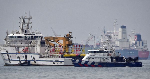 一艘新加坡警察海岸卫队船只，在新马之间的水域驶过一两大马政府船只（左）。（海峡时报） 