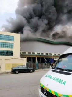 救护车停在起火的家私厂，准备进行救援。