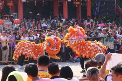 除了恭迎神明圣驾出巡，民众也不忘拍下柔佛福清会馆舞狮表演的一幕。