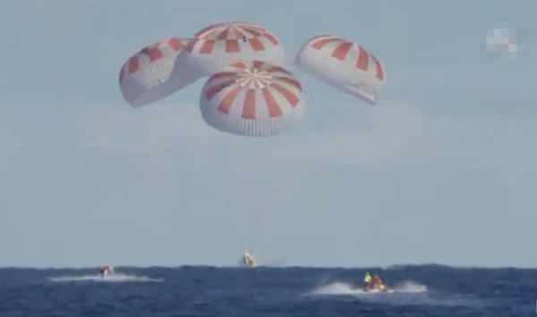 美国太空船“载人飞龙号”星期五回返地球，顺利打开降落伞，在佛罗里达州预设海域降落。（欧新社） 