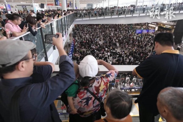 数以百计黑衣示威者星期五聚集在香港机场大厅，向外国游客控诉香港政府及警方在“反送中”运动的作为，呼吁勿再相信香港警察。（欧新社）