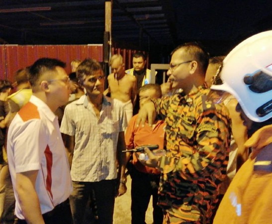 邹宇晖（左）向消拯人员了解灭火行动进展。
