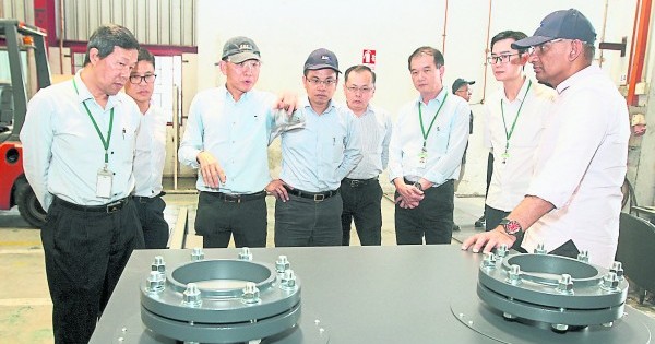 张汉伟（左三）向评审讲解机械的用途。右起为古马拉拉惹、陈汉光、刘鸿辉、韩铭畴及蔡兆源；左起为傅德发及谭敬豪。 