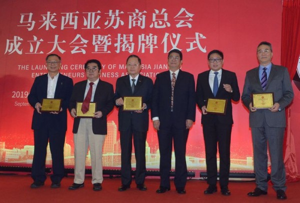 吕小鹏（右三）颁发马来西亚苏商总会荣誉会长牌匾予锺少云（左起）、陈天来、郑福成，刘绪铭（右起）及赖俊瀚后，6 人同台合影。