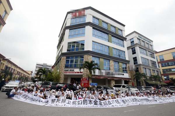 逾300名男女在一间公司的办公楼外静坐抗议。 