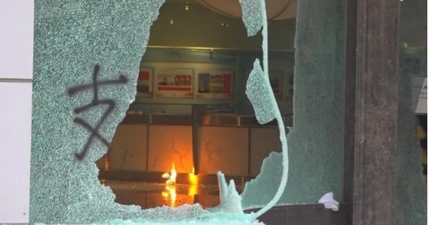 新华社星期日凌晨公布了被砸现场内部角度的图片。大门玻璃上被喷漆，只见一个支字，另一边则已被砸烂。（新华网）