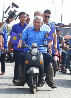 阿末扎希到龟咯为国阵助选，并骑上摩托车离开。