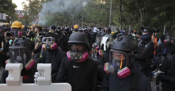 蒙面黑衣人日前在香港中文大学校园内与警方对峙。（美联社） 
