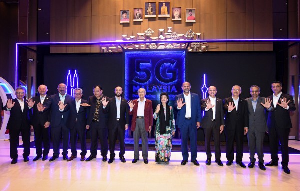 马哈迪（中）与一众嘉宾比出象征“5G”的手势，标志浮罗交怡的5G大马示范项目正式启动。左五起为依丁沙兹里及慕克力；右五起为哥宾星及茜蒂哈丝玛。
