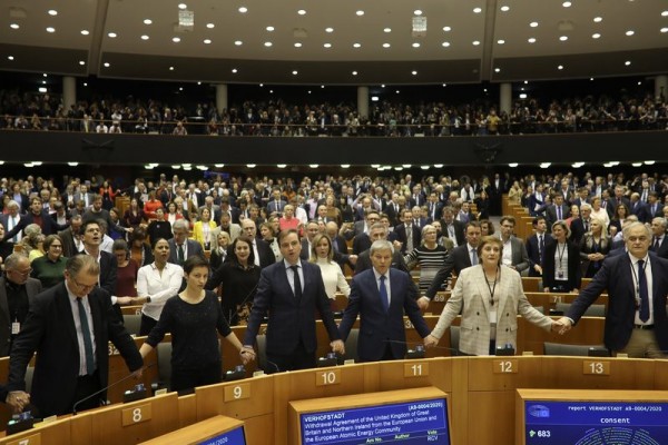 欧洲议会投票结束后，在场议员手拉手唱起苏格兰经典歌曲《友谊地久天长》，送别英国。（美联社） 